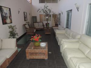 Sala de estar con sofás blancos y mesa de centro en Hotel Paola Antofagasta, en Antofagasta