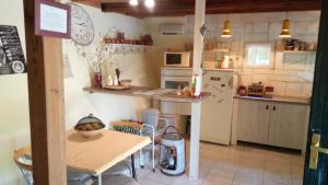a small kitchen with a table and a refrigerator at Holiday home Mrežnički šum in Generalski Stol