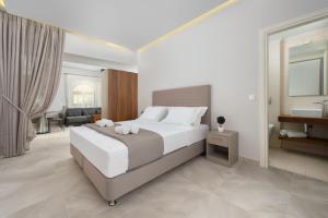 a bedroom with a large bed and a bathroom at Lardos Luxury Apartments in Lartos