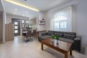 a living room and kitchen with a couch and a table at Lardos Luxury Apartments in Lartos