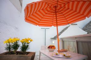 アルベロベッロにあるIl Trullo di Mastro Stefanoのオレンジの傘を掛けたテーブル
