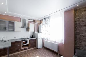 une cuisine avec un réfrigérateur blanc et une fenêtre dans l'établissement VIP Apartment on Shishkarevskaya, à Soumy
