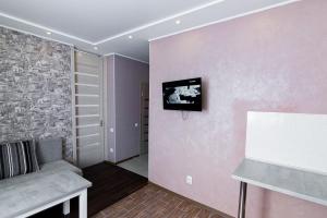 - un salon avec un canapé et une télévision murale dans l'établissement VIP Apartment on Shishkarevskaya, à Soumy