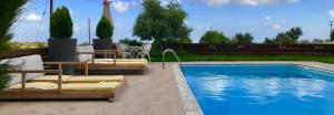 a swimming pool with two lounge chairs and a table at Villa Grand Zeus in Anoyira