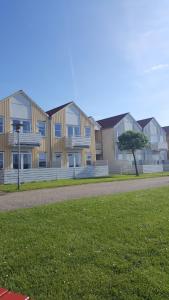 eine Reihe von Häusern in einem Park mit einem Baum in der Unterkunft Private Apartment Skudehaven in Rudkøbing