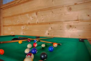 a green pool table with billiard balls and cues at Pokoje u Borzana in Biały Dunajec