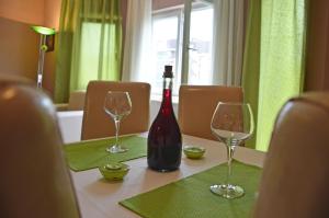 a bottle of wine sitting on a table with two glasses at Apartments Vila Vrdnik in Vrdnik