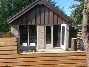a house with a bench on a wooden deck at Texelduinen59 in De Koog