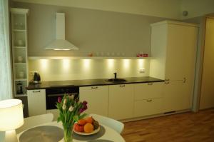 a kitchen with a sink and a table with a bowl of fruit at Modern apartment in Old town in Pärnu