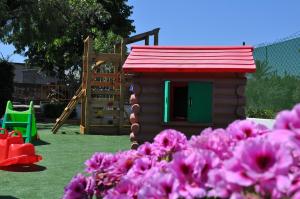 a small dog house in a yard with pink flowers at Terra Mia in Formia