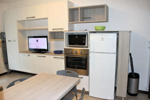 グラードにあるAppartamenti Elenaのキッチン(白い冷蔵庫、テレビ付)