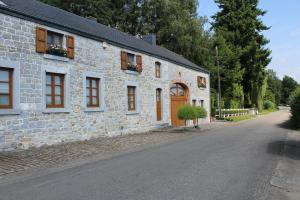 a stone building with windows on a street at Gïte de l'EHM in Custinne