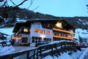 budynek z lampkami świątecznymi na śniegu w obiekcie Garni Hotel and Apartments Wildbach w mieście Selva di Val Gardena