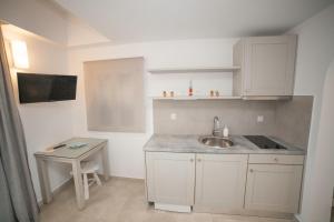 a small kitchen with a sink and a table at Skopelitis Village in Katapola