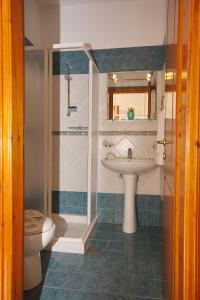 a bathroom with a sink and a shower and a toilet at Alexandra Studios in Kalamakia