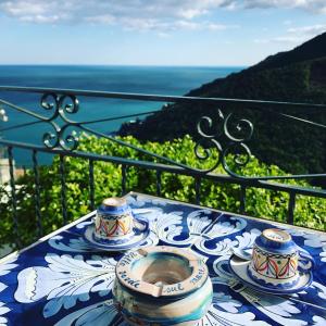 a table with plates and bowls on top of a balcony at villa verde sul mare in Vietri sul Mare