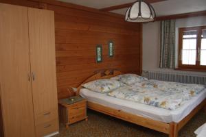 a bedroom with a bed and a wooden wall at Ferienhaus Reiter Lotte in Gosau
