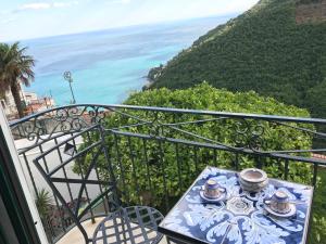 a table on a balcony with a view of the ocean at villa verde sul mare in Vietri sul Mare