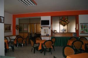 a dining room with tables and chairs and a tv at Albergo Ristorante Pace in Bognanco