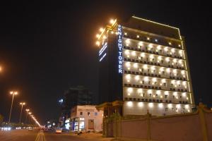 a hotel building with lights on it at night at Burj Al Faris Hotel Apartments in Jeddah
