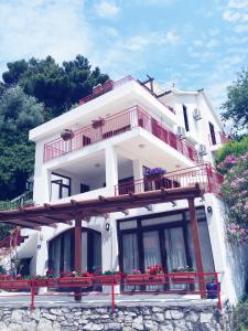 Una casa blanca con balcón y flores. en Apartments Almaja Villa, en Petrovac na Moru
