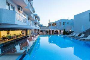 uma grande piscina ao lado de um edifício em Castello Bianco Aparthotel em Platanes