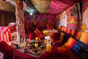 un ristorante con un tavolo e sedie in una stanza di Desert Bivouac Mhamid a M'Hamid