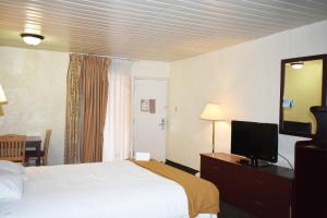 a hotel room with a bed and a desk with a television at Knights Inn Page in Page