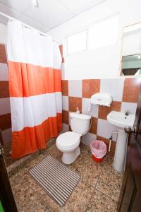 a bathroom with a toilet and a sink at Papaya Lodge in La Libertad