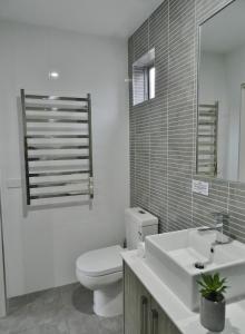 y baño con aseo, lavabo y espejo. en Motel 24, en Wodonga
