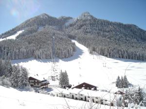 una montaña cubierta de nieve con un lodge de esquí. en Hotel Spampatti, en Castione della Presolana