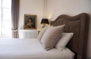 um quarto com uma cama e um retrato de uma mulher em Hôtel Marie-Rollet em Cidade de Quebec