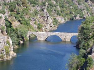 a bridge in the middle of a river at Sossego in Pedrógão Grande +3 photos