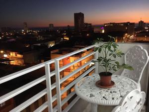 una mesa blanca y una silla en un balcón con una planta en Arriendo Diario Iquique, en Iquique