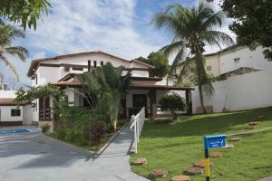 uma casa com uma placa em frente a um quintal em Pousada Eldorado em Lauro de Freitas