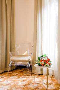 a chair and a table with a bouquet of flowers at Sintra Boutique Hotel in Sintra