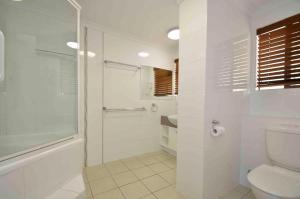 a white bathroom with a shower and a toilet at Bellardoo Holiday Apartments in Mooloolaba +37 photos