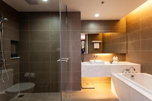 a bathroom with a shower and a sink and a tub at Best Western Premier Sukhumvit in Bangkok