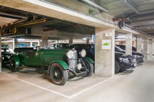 a green car parked in a garage with other cars at Dukes' Academie Brugge - by Dukes' Hotel Collection in Bruges