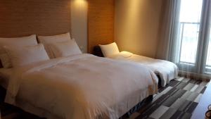 Postel nebo postele na pokoji v ubytování Watermark Hotel Kaohsiung Main Station