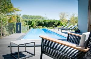 a swimming pool with a bench and a table at MAISON KERVARREC - Rennes - Saint-Grégoire in Saint-Grégoire