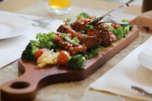 a plate of food with broccoli and meat on a table at New Space Hotel Airport in Ho Chi Minh City