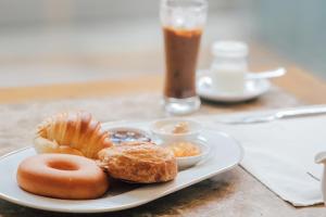 a plate of food with donuts and a drink at New Space Hotel Airport in Ho Chi Minh City