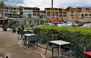um grupo de mesas e cadeiras num parque de estacionamento em Domaine de la Coudoulière, T2 climatisé terrasse vue mer sans vis à vis plage à 100m em Six-Fours-les-Plages