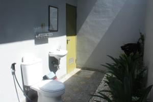 a bathroom with a toilet and a sink at Purnama Guesthouse in Canggu