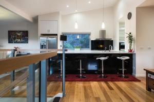 a kitchen with a counter and stools in it at Azura in Daylesford