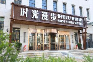 张家口Nostalgia Hotel Zhangjiakou- Near The Grass Skyline, Dajingmen, 20 minutes away from Zhangjiakou High-speed Railway Station, Free ice cream, mineral water, coffee, snacks and laundry service, English communication well的一栋带有受虐狂酒店标志的建筑