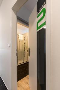a door leading into a bathroom with a sign at Wein4tler-Motel in Gänserndorf