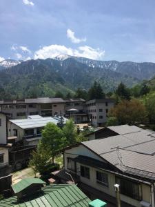 um grupo de edifícios com montanhas ao fundo em Hotel Hirayunomori Annex em Takayama
