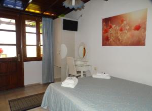 sypialnia z łóżkiem, biurkiem i obrazem w obiekcie Anemones Rooms w Chanii